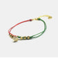 Bracelet with green and red strings and gold beads on a white background