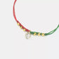 Bracelet with red, green, and gold beads and a clear crystal charm on a white background