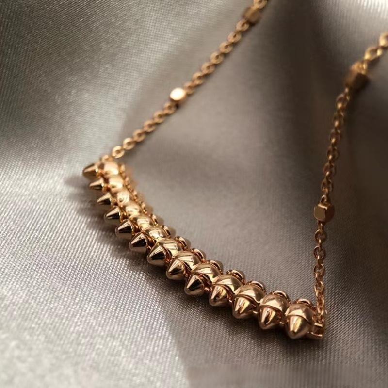 Clash de Cartier pendantGold necklace with spike-like designs on a metallic surface