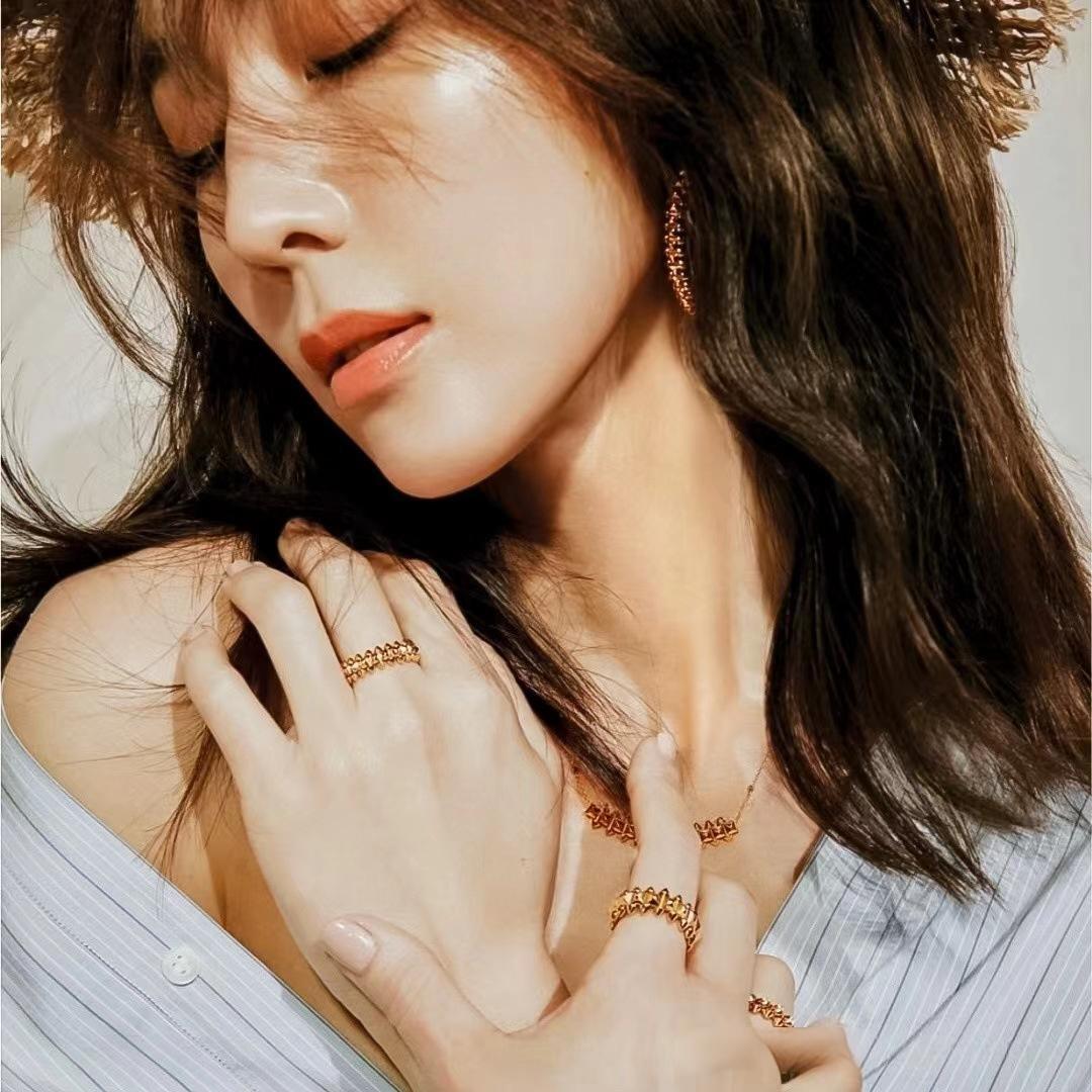 CClash de Cartier pendantlose-up of a woman wearing gold jewelry with a neutral background