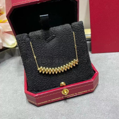 Clash de Cartier pendantGold necklace in a red jewelry box on a gray surface