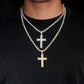 Two cross necklaces with diamond accents on a black background