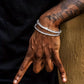 Hand with a silver bracelet and tattoo on a dark background