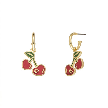 A pair of gold-tone drop earrings featuring cherry charms with red enamel fillings and green leaves, shown on a plain white background.