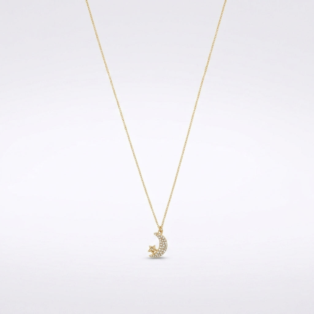 A delicate gold chain necklace featuring a crescent moon and star pendant adorned with small clear stones, set against a clean white background.