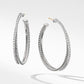 Pair of silver hoop earrings on a light gray background