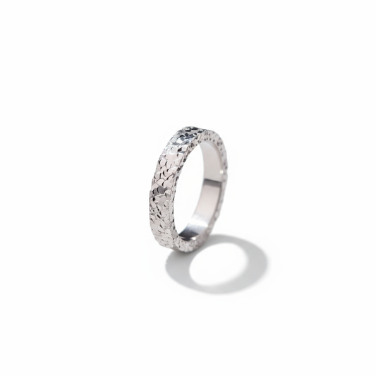 Silver ring with textured band on a white background