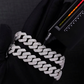 Silver chain bracelet on a black background with a scale for size reference.