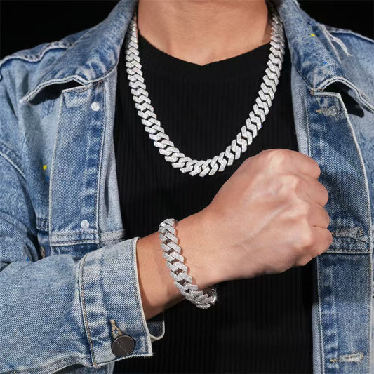 Person wearing a silver chain necklace and bracelet with a denim jacket.
