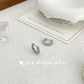 Silver hoop earrings on a textured surface with a card in the background, featuring 'jsew design silver' branding.