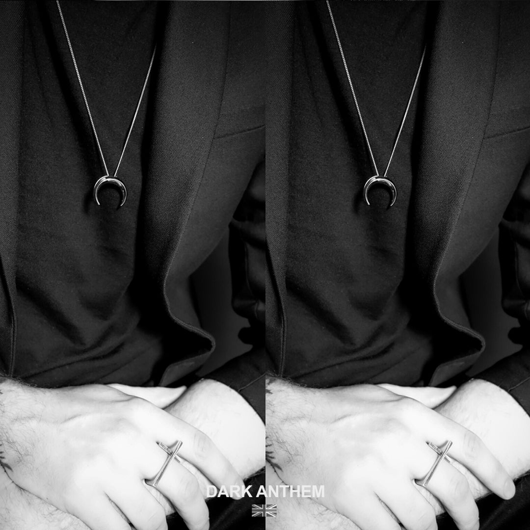 Black and white split-screen of a necklace with a pendant and a ring on a person's finger, with 'Dark Anthem' branding.