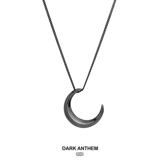 Crescent moon-shaped pendant necklace on a white background with 'Dark Anthem' branding.