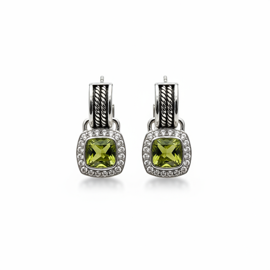 Silver earrings with green gemstones on an orange box