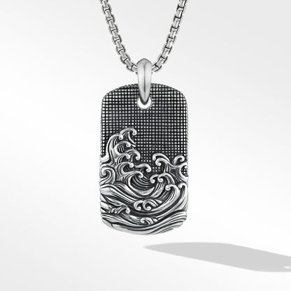 Silver dog tag pendant with wave design on a white background