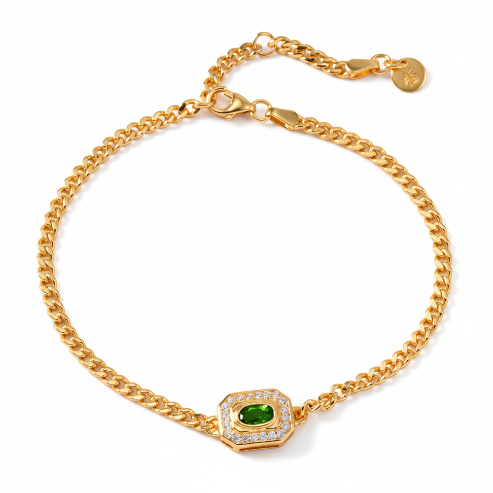 Gold bracelet with a green gemstone on a white background