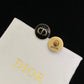 Dior earrings on a Dior branded cloth with a black background