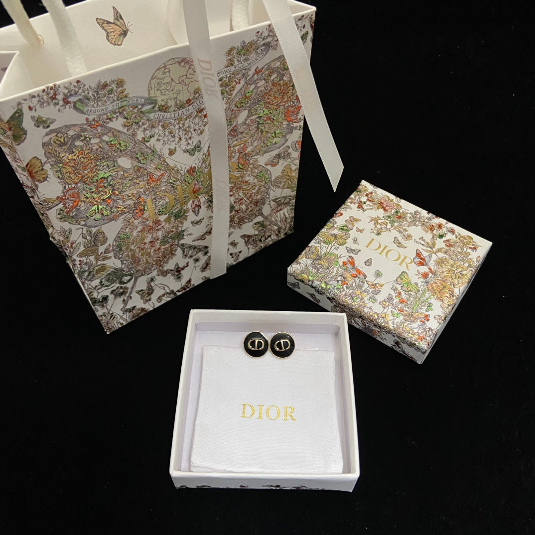 Dior earrings in a box with a decorative Dior bag in the background