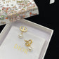Gold and pearl earrings in a Dior box with a floral design on the lid.