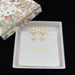 Gold and pearl earrings in a Dior box on a black background