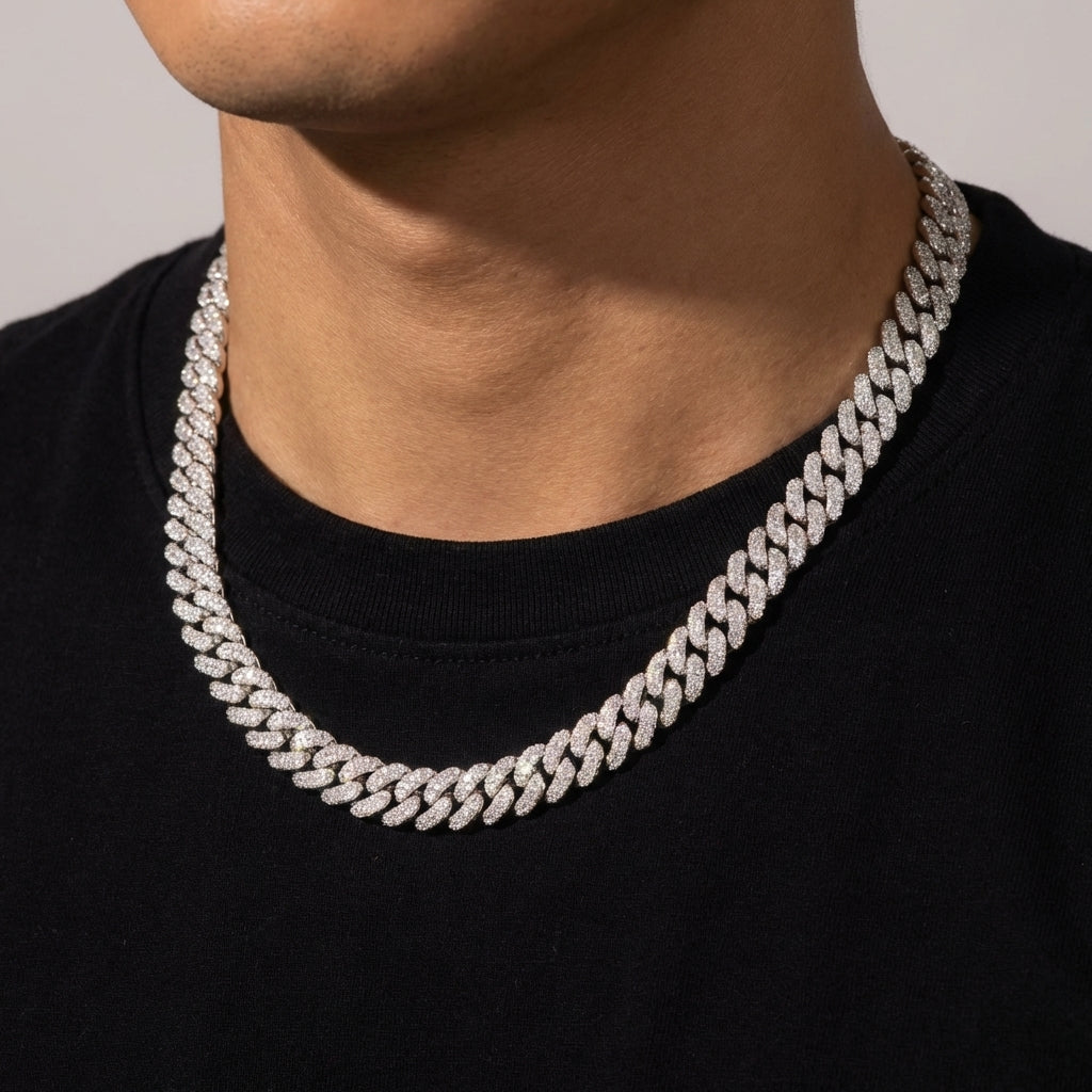 Silver chain necklace worn by a person on a plain background