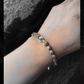 Bracelet with beaded design on a wrist against a dark background