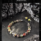 Hand-woven bracelet with colorful beads on a dark stone surface