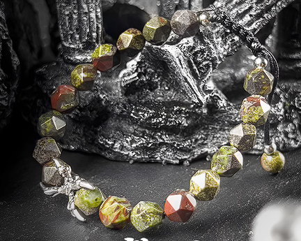 Necklace with green and red beads on a dark background