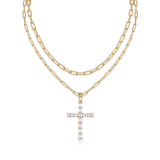 Clean white background — the emerald cut moissanite cross pendant layered with a delicate solo chain on a bust form. The cross catches light, showing the distinctive step-cut facets and brilliant sparkle. Chains drape gracefully without tangling.