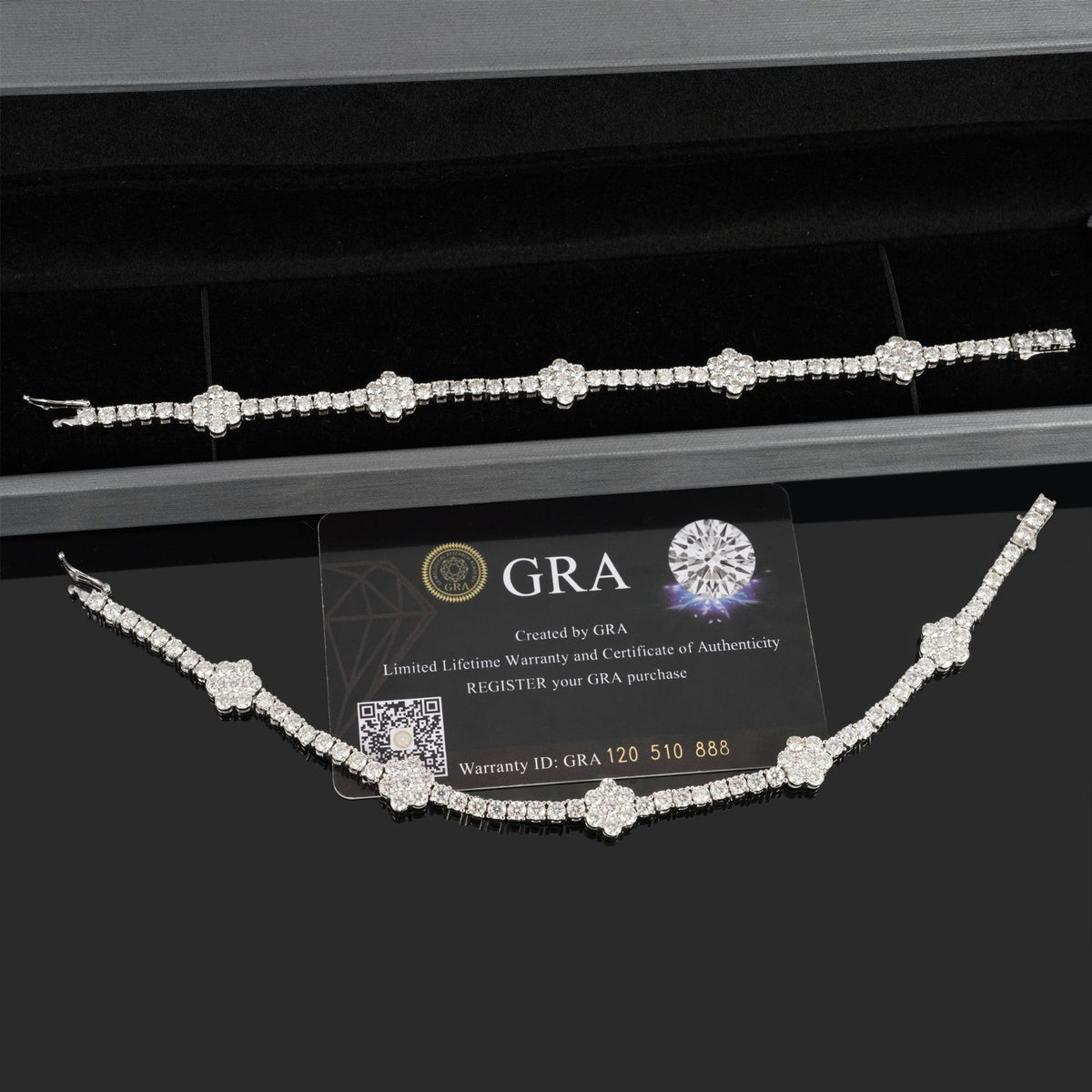 A diamond necklace and matching bracelet displayed on a black jewelry box, with a GRA certification card in the center. The jewelry is set in silver-toned metal with clear gemstones, and the background is a black velvet presentation box.
