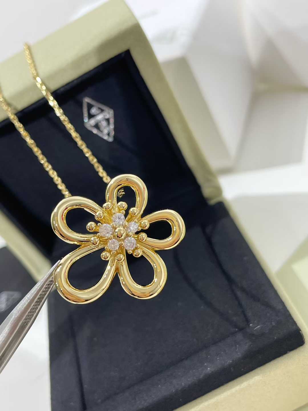 “Flowerlace style gold plated pendant necklace flat lay”