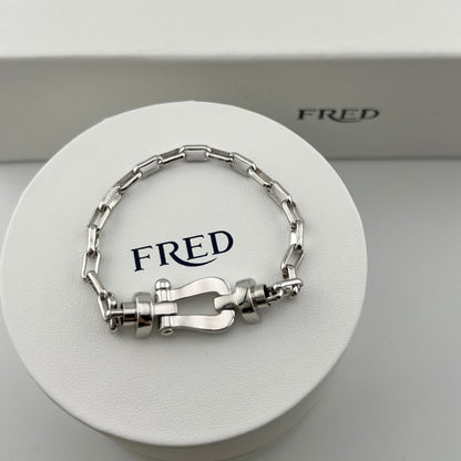 Silver bracelet on a white circular stand with 'FRED' branding.