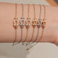 Set of gold and silver bracelets on a wrist against a neutral background