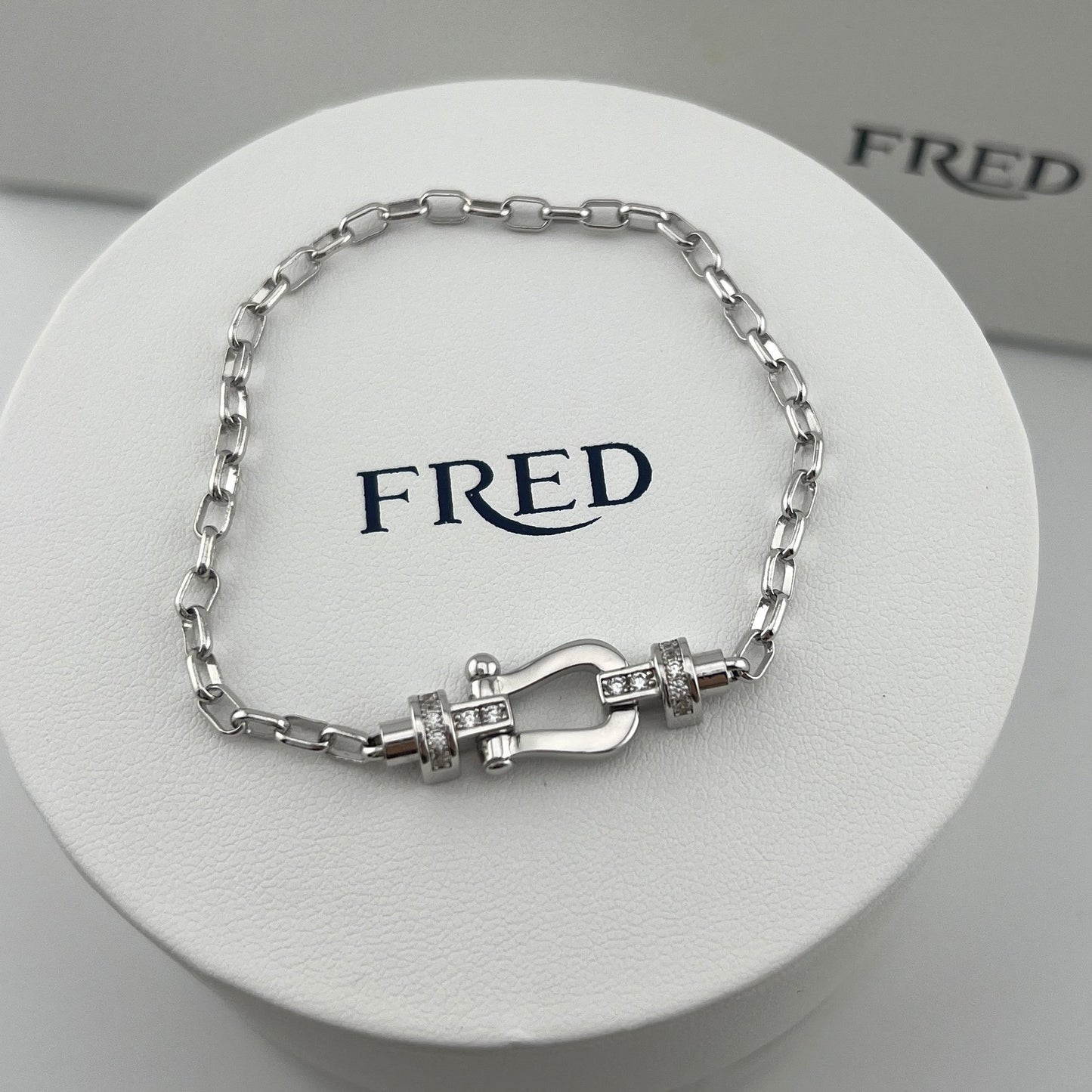 Silver bracelet on a white display with 'FRED' branding