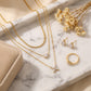 Top-down, necklaces on marble tray, styled with earrings, ring, dried flower, velvet box, warm soft tones, balanced composition, clean e-commerce aesthetic, high resolution.