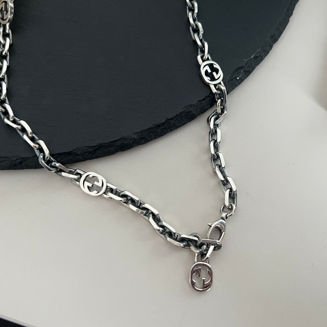 “Gucci 3 interlocking GG stations silver necklace flat lay”