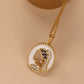 Gold necklace with a heart-shaped pendant on a beige background