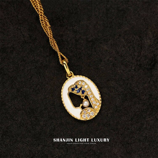 Gold necklace with a decorative pendant on a black background, featuring the brand 'SHANJIN LIGHT LUXURY'.