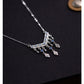 Silver necklace with dangling charms on a dark background