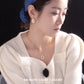 Woman wearing a blue headband and white sweater with jewelry, branded 'SHANJIN LIGHT LUXURY'.