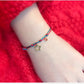 Bracelet with a star charm on a wrist against a red background