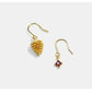 Two gold earrings with gemstones on a white background