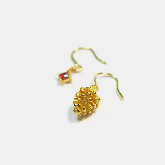 Gold pineapple-shaped earrings on a white background