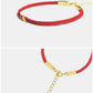Red bracelet with gold accents on a white background