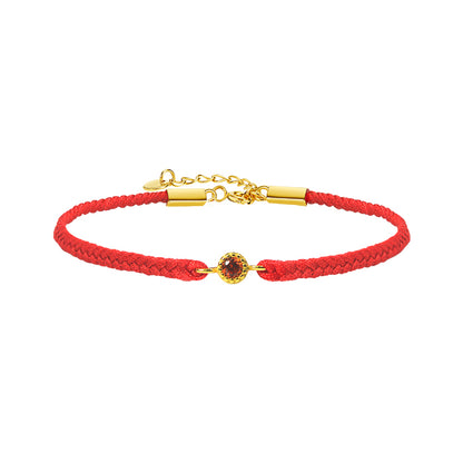Red braided bracelet with a gold clasp and gemstone on a white background