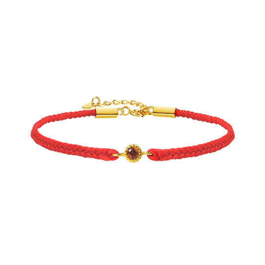 Red braided bracelet with a gold clasp and gemstone on a white background
