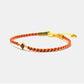 Bracelet with red and gold braided design on a white background