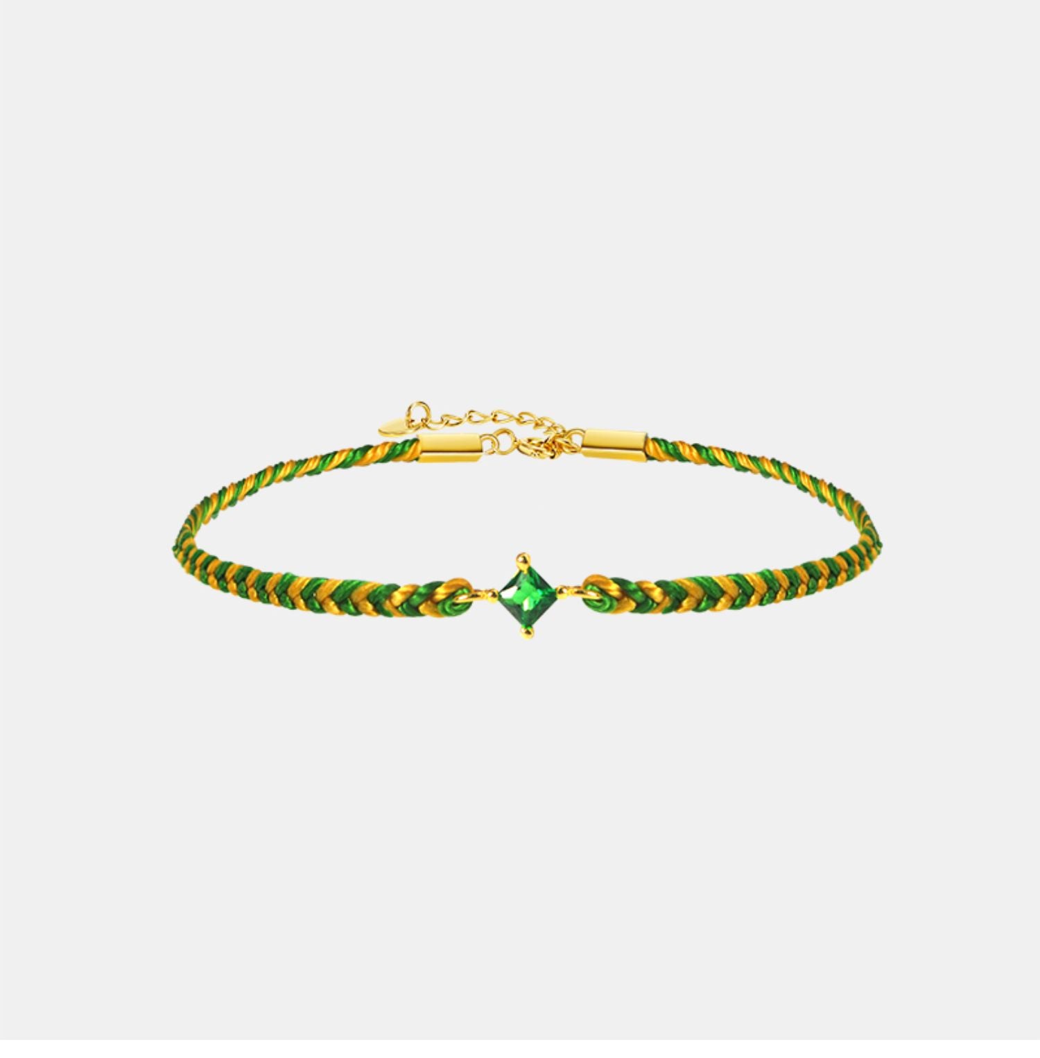 Green and gold bracelet with a central gemstone on a light gray background