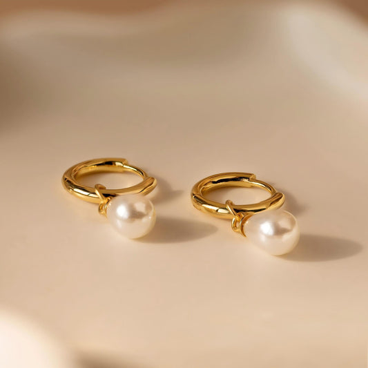 Earrings on soft cream or blush background. Alt: “Gold Pearl Drop Huggie Earrings – Freshwater Pearl Jewelry.”