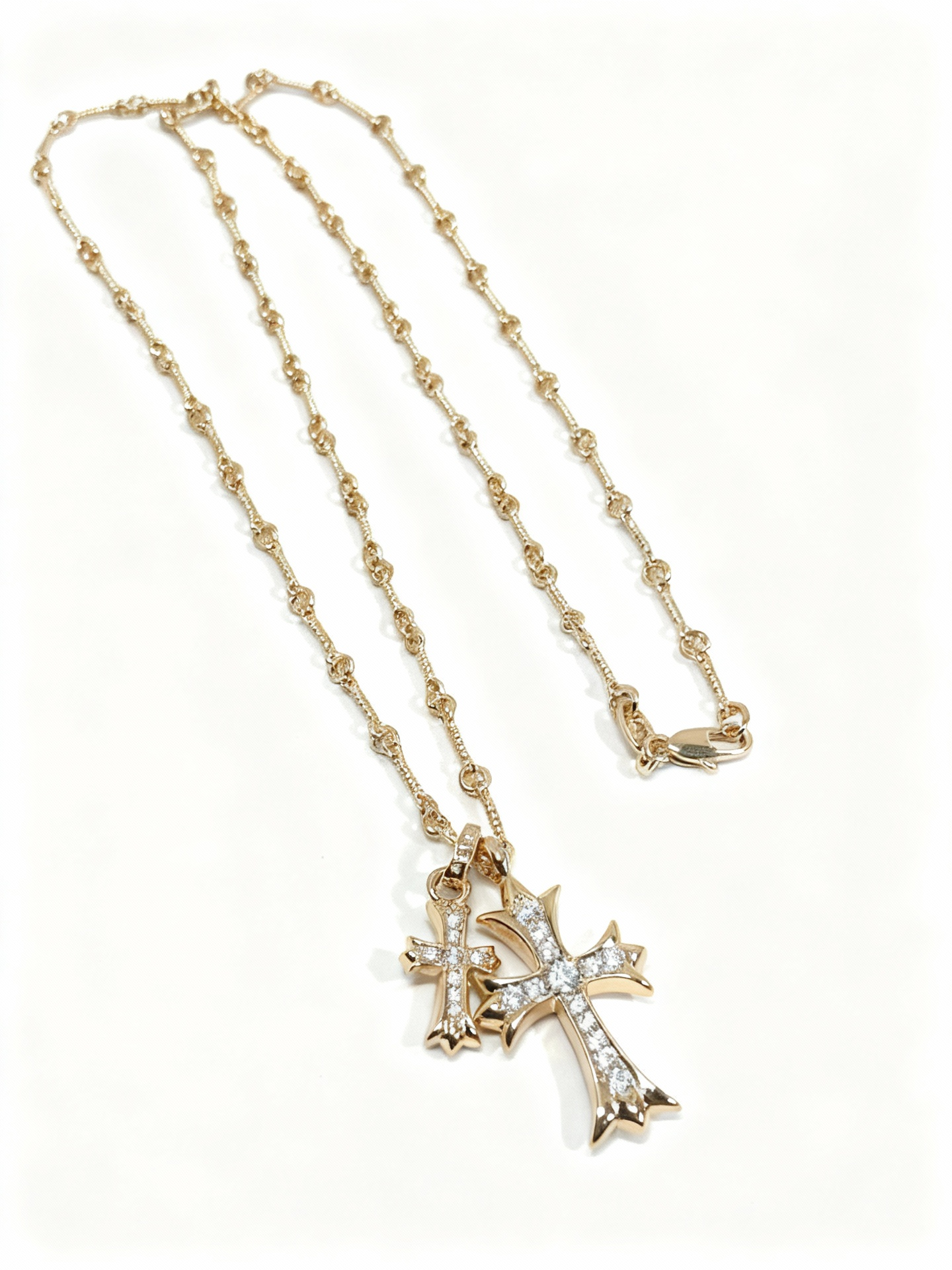 “Gold and silver double cross necklace flat lay showing zircon pendant and link chain”