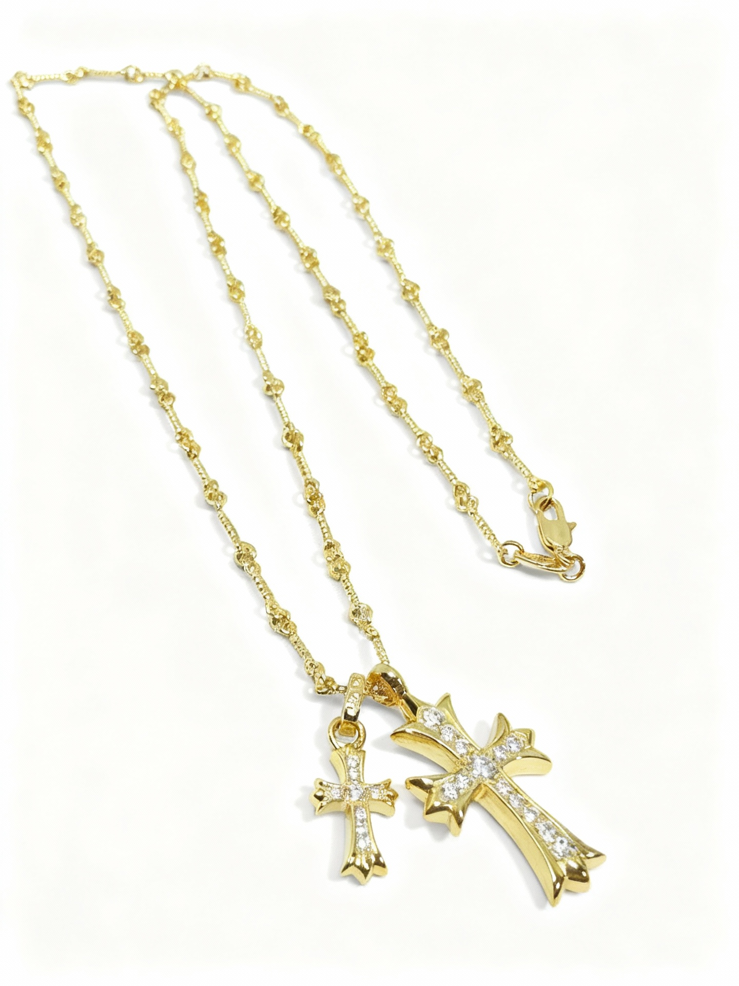 “Gold and silver double cross necklace flat lay showing zircon pendant and link chain”